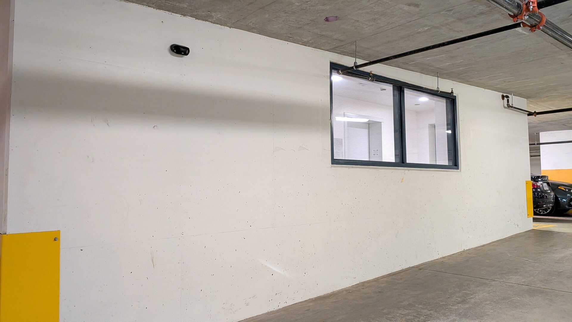 Compact camera mounted high on a parkade wall