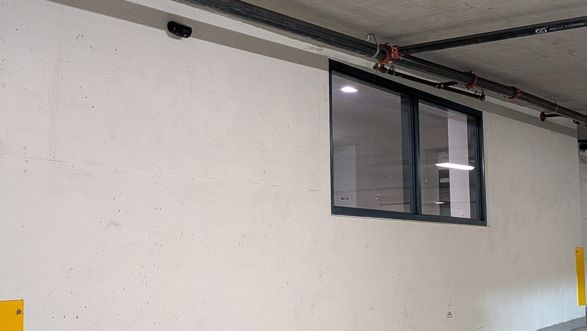 Close view of a low-profile camera on a concrete wall