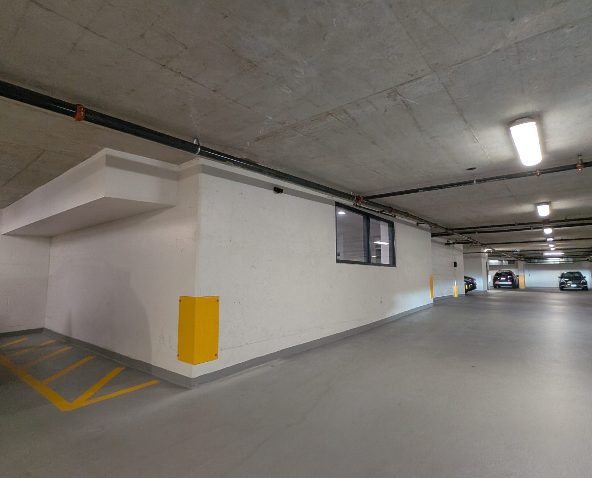 Wide view of a parkade level with wall-mounted cameras
